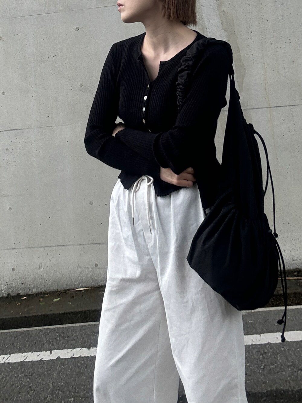 ブラック系のカーディガン/ボレロ、ホワイト系のその他パンツ、ブラック系のスリッポンを着用したレディースの春コーディネートの2枚目の写真