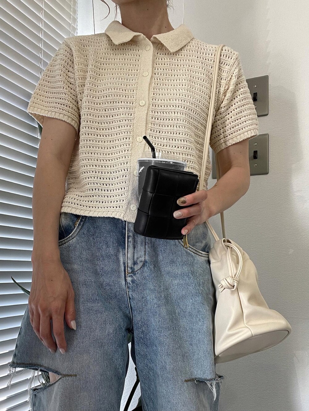 ホワイト系のカーディガン/ボレロ、ブルー系のデニムパンツ、ホワイト系のスニーカーを着用したレディースの夏コーディネートの3枚目の写真