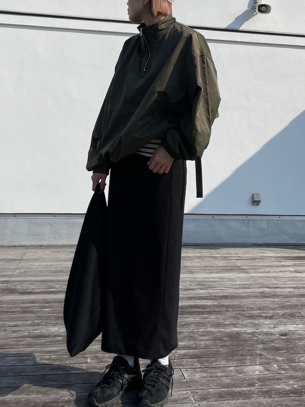 グリーン系のその他アウター、ブラック系のスカート、ホワイト系のTシャツ/カットソーを着用したレディースの秋コーディネートの3枚目の写真