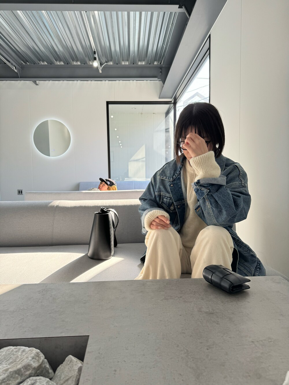 ホワイト系のニット/セーター、ブルー系のデニムジャケット、ブラック系のブーツを着用したレディースの冬コーディネートの3枚目の写真