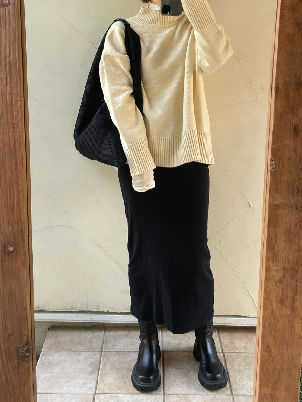 ホワイト系のTシャツ/カットソー、ブラック系のトートバッグ、ブラック系のブーツを着用したレディースの秋コーディネートの2枚目の写真