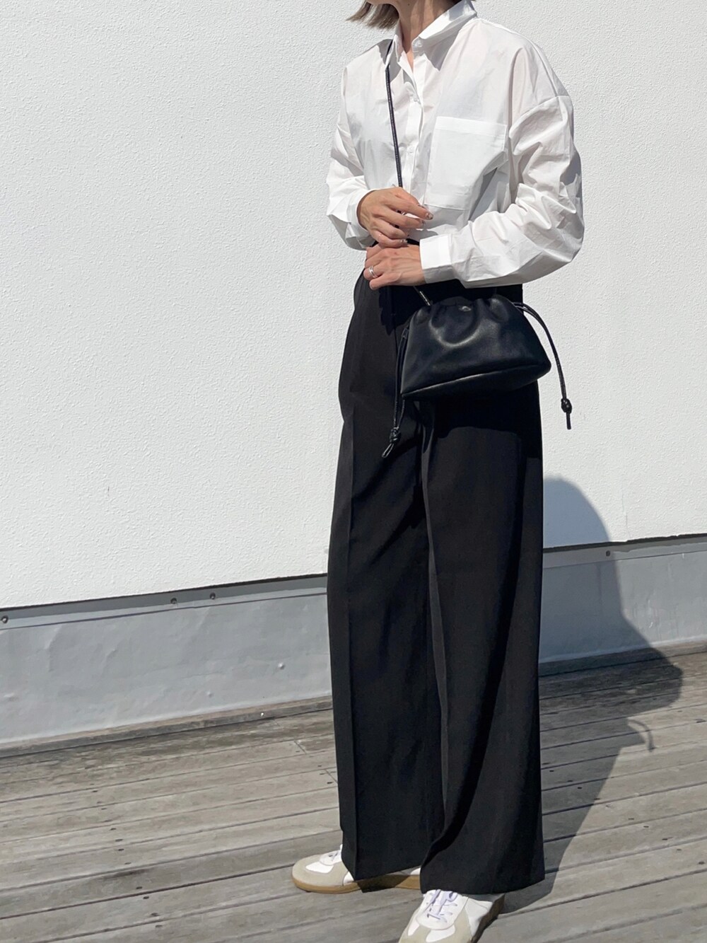 ホワイト系のシャツ/ブラウス、ブラック系のハンドバッグ、ブラック系のパンツを着用したレディースの秋コーディネートの3枚目の写真