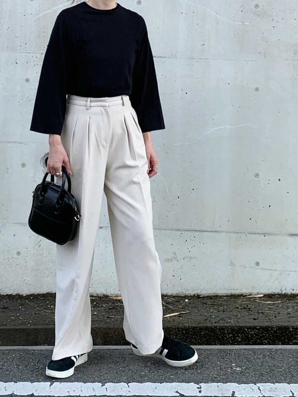 ブラック系のTシャツ/カットソー、ホワイト系のチノパンツ、ブラック系のスニーカーを着用したレディースの秋コーディネートの2枚目の写真
