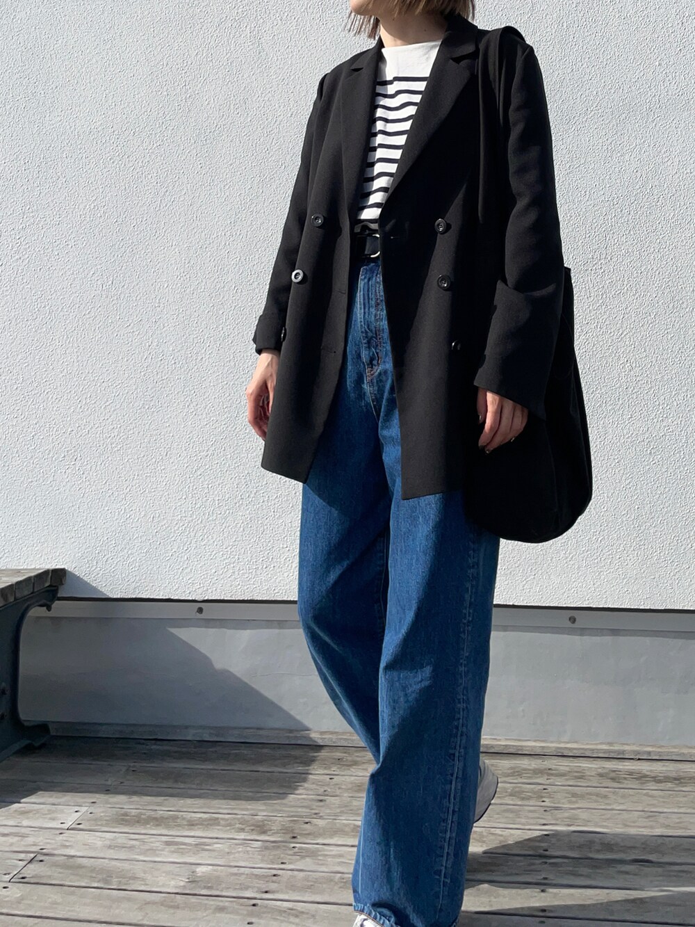 ブルー系のTシャツ/カットソー、ブラック系のテーラードジャケット、ブルー系のデニムパンツを着用したレディースの春コーディネートの2枚目の写真