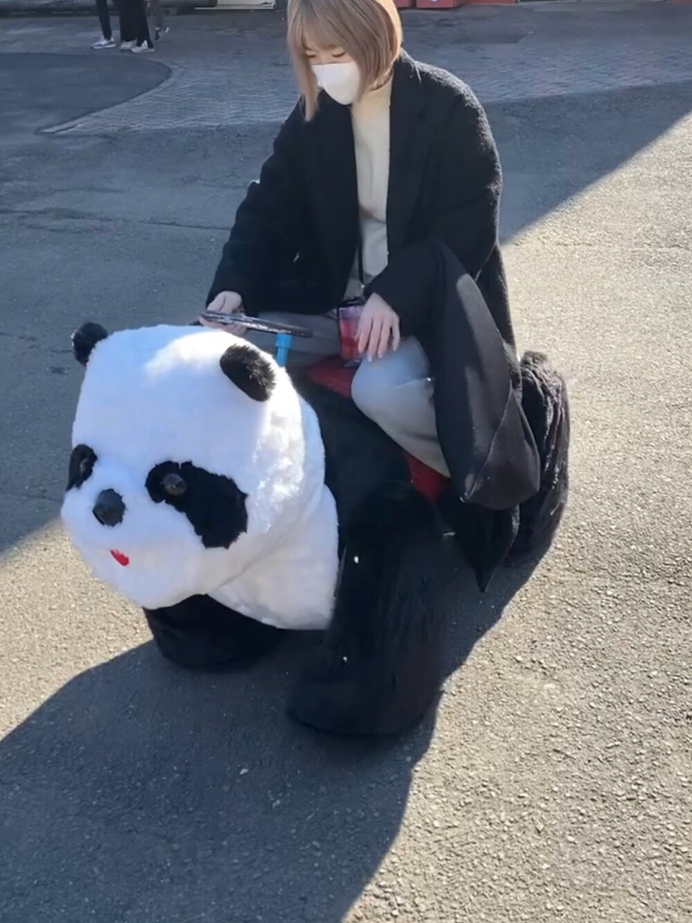 ホワイト系のニット/セーター、グレー系のスウェットパンツ、ブラック系のスニーカーを着用したレディースの冬コーディネートの2枚目の写真