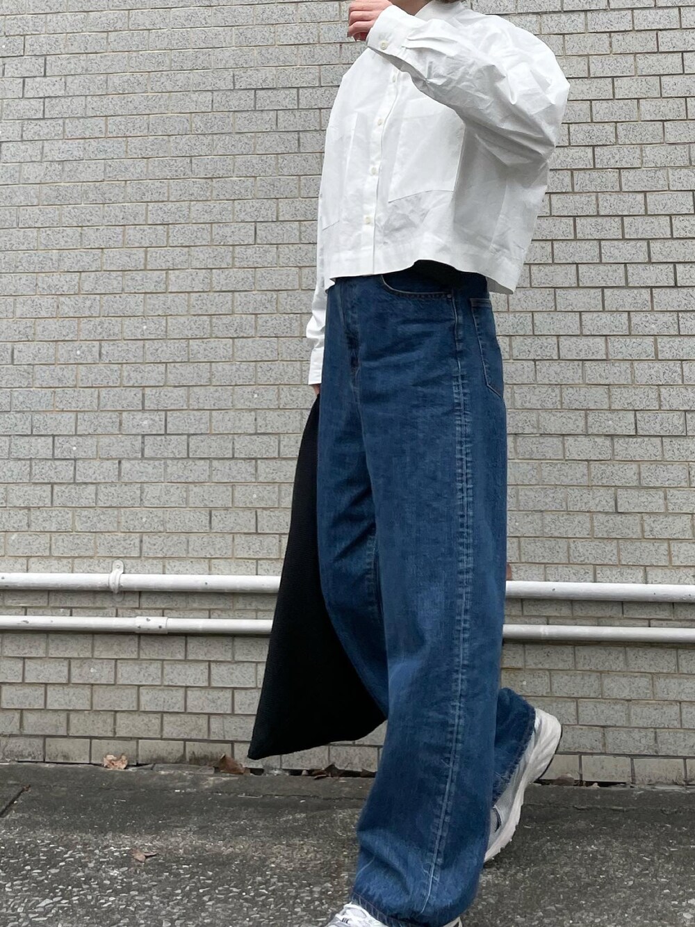 ホワイト系のシャツ/ブラウス、ブルー系のデニムパンツ、ブラック系のトートバッグを着用したレディースの春コーディネートの2枚目の写真