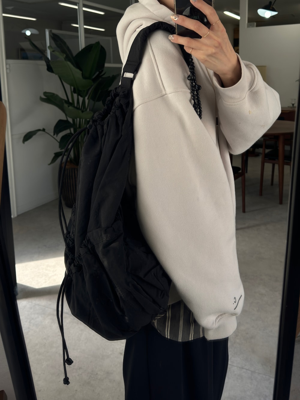 グレー系のパーカー、グレー系のシャツ/ブラウス、ブラック系のショルダーバッグを着用したレディースの春コーディネートの2枚目の写真