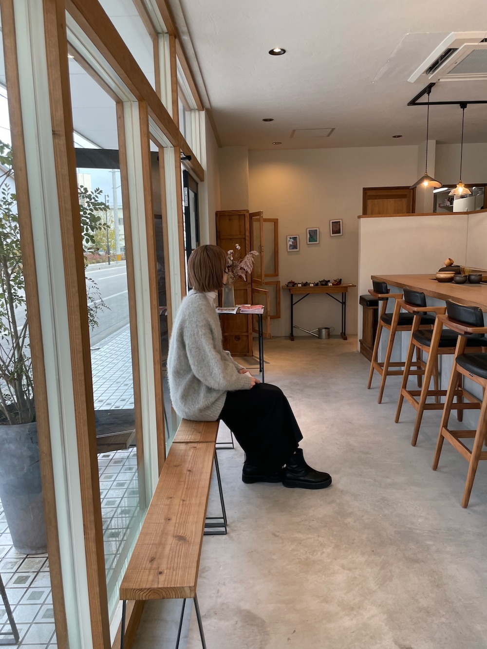 グレー系のカーディガン/ボレロ、ホワイト系のTシャツ/カットソー、ブラック系のスカートを着用したレディースの冬コーディネートの2枚目の写真