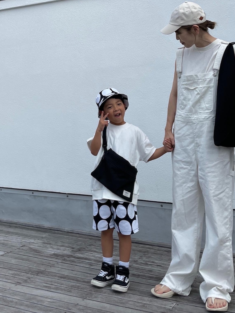 ホワイト系のサロペット/オーバーオール、ブラック系のトートバッグ、ホワイト系のサンダルを着用したレディースの夏コーディネートの2枚目の写真