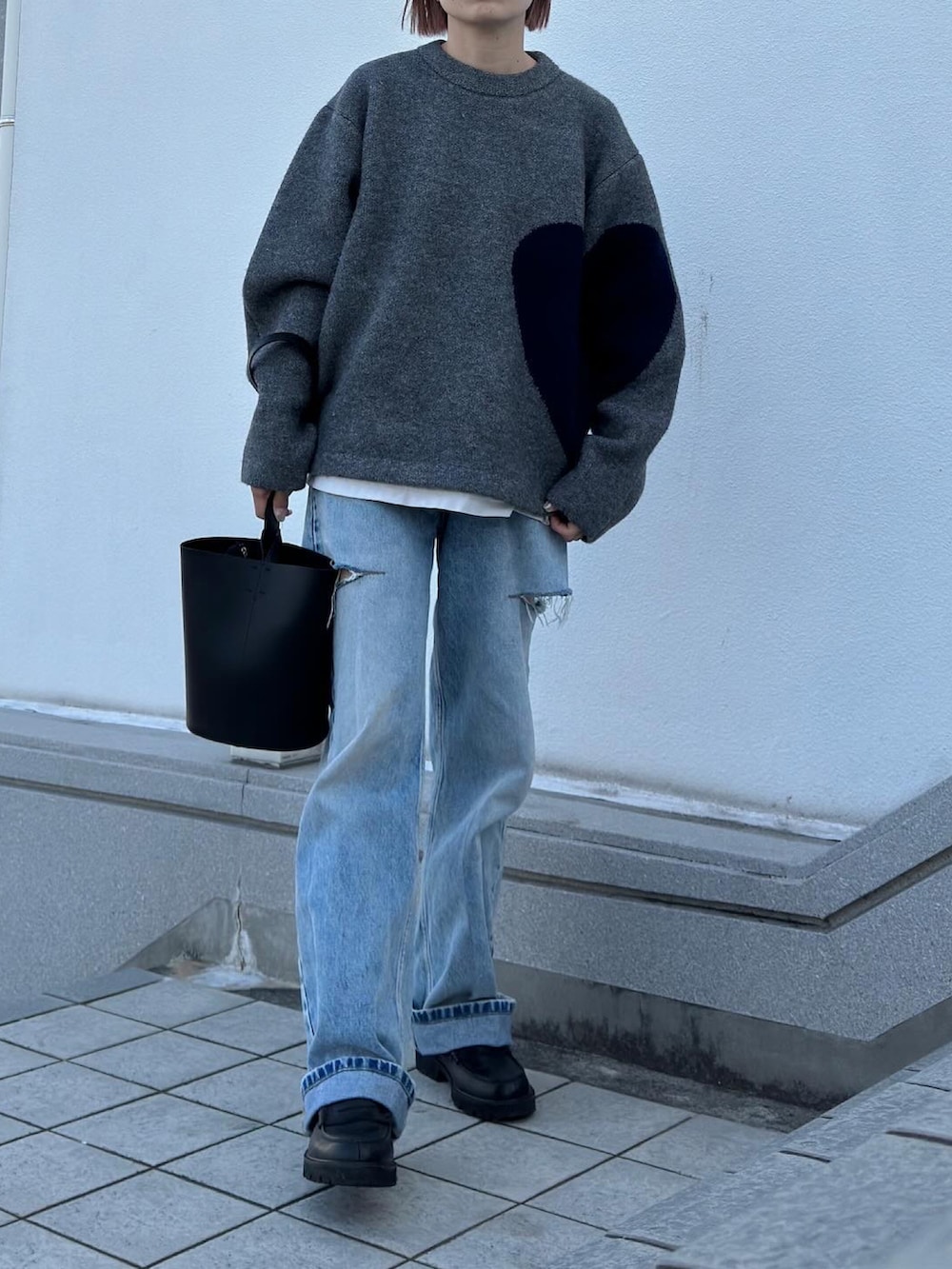 グレー系のニット/セーター、ブルー系のデニムパンツ、ブラック系のローファーを着用したレディースの秋コーディネートの3枚目の写真