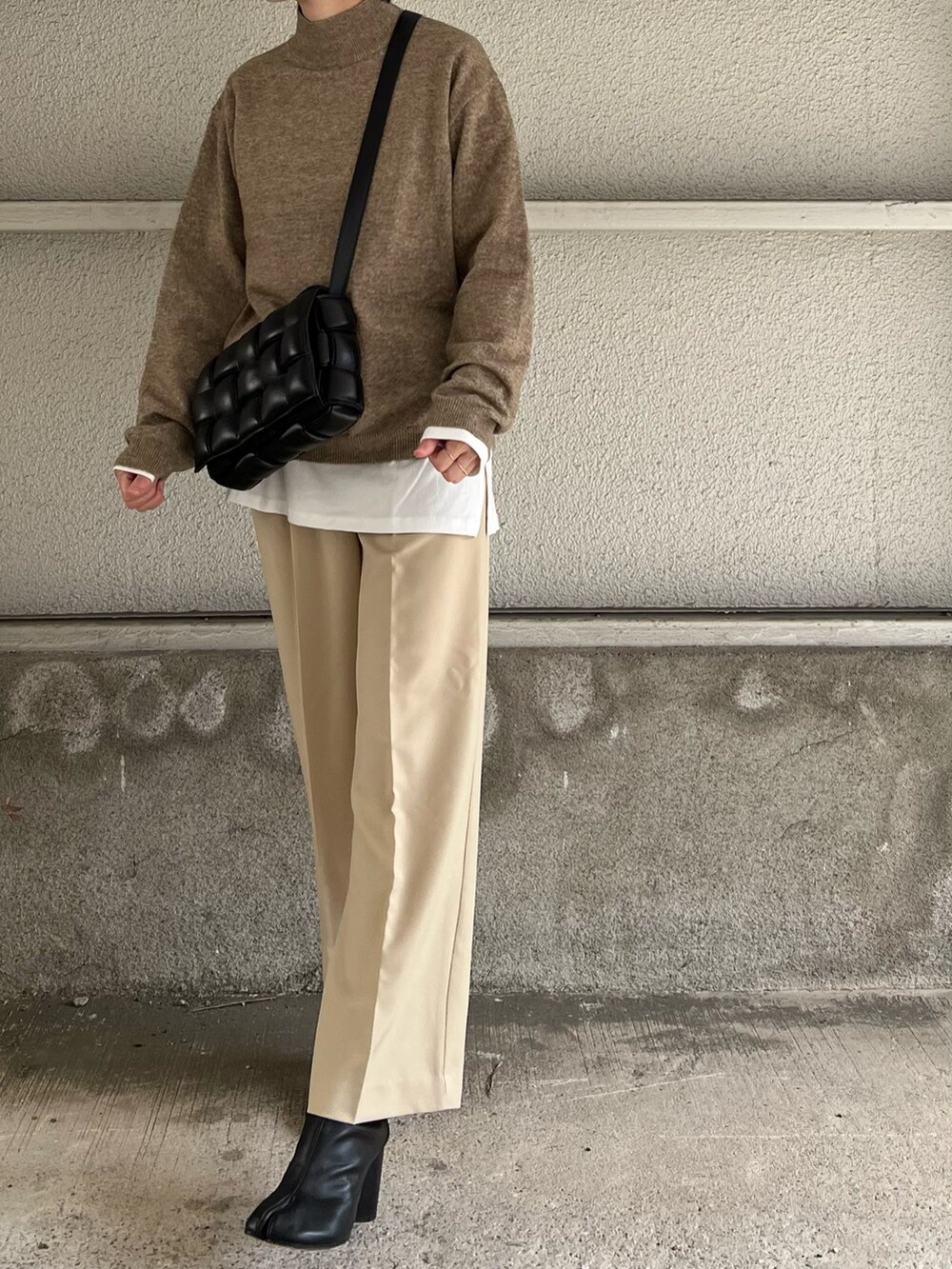 ブラック系のショルダーバッグ、ブラック系のブーツ、ホワイト系のTシャツ/カットソーを着用したレディースの冬コーディネートの2枚目の写真