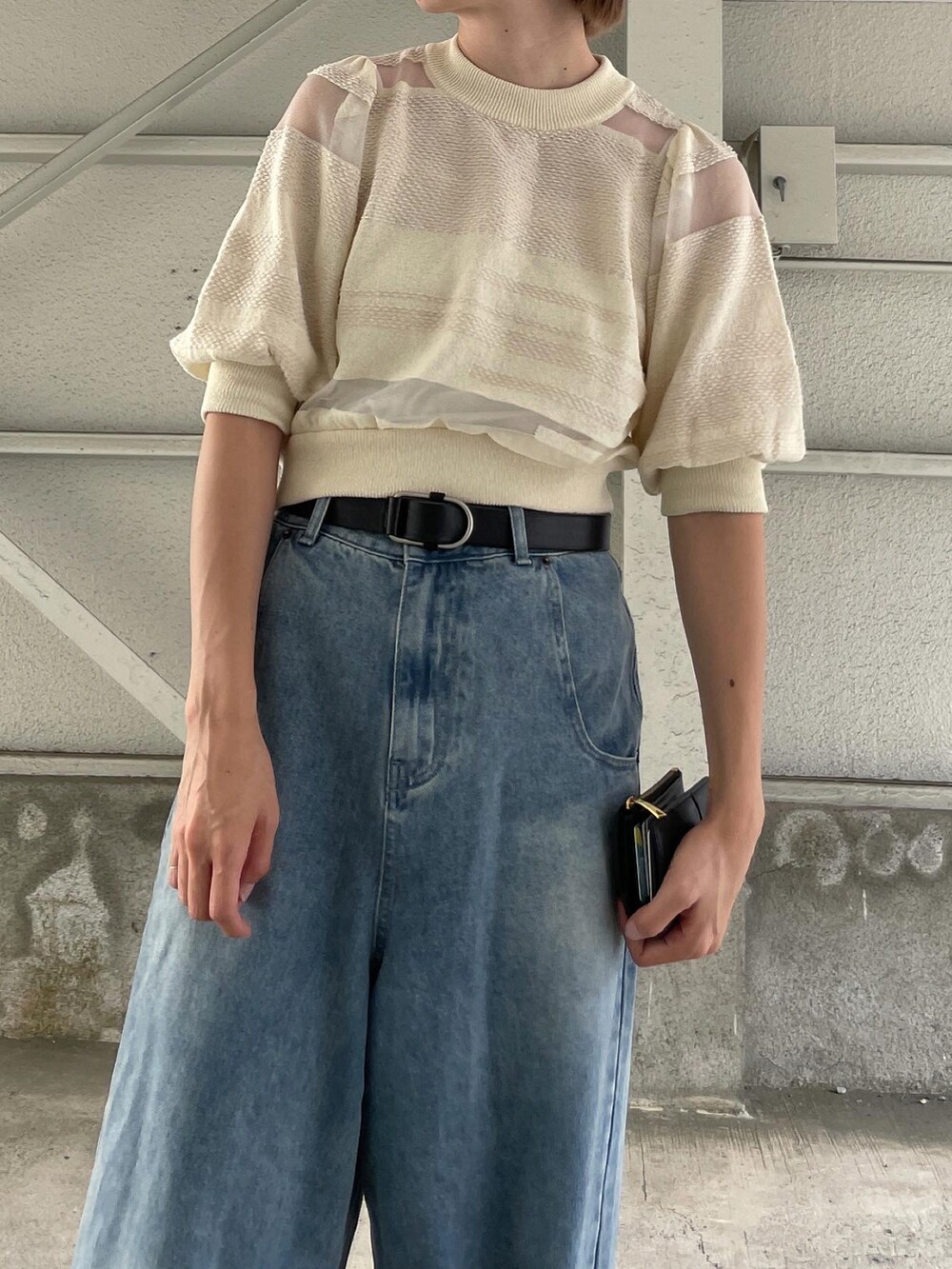 ホワイト系のニット/セーター、ブルー系のデニムパンツ、ベージュ系のサンダルを着用したレディースの秋コーディネートの3枚目の写真