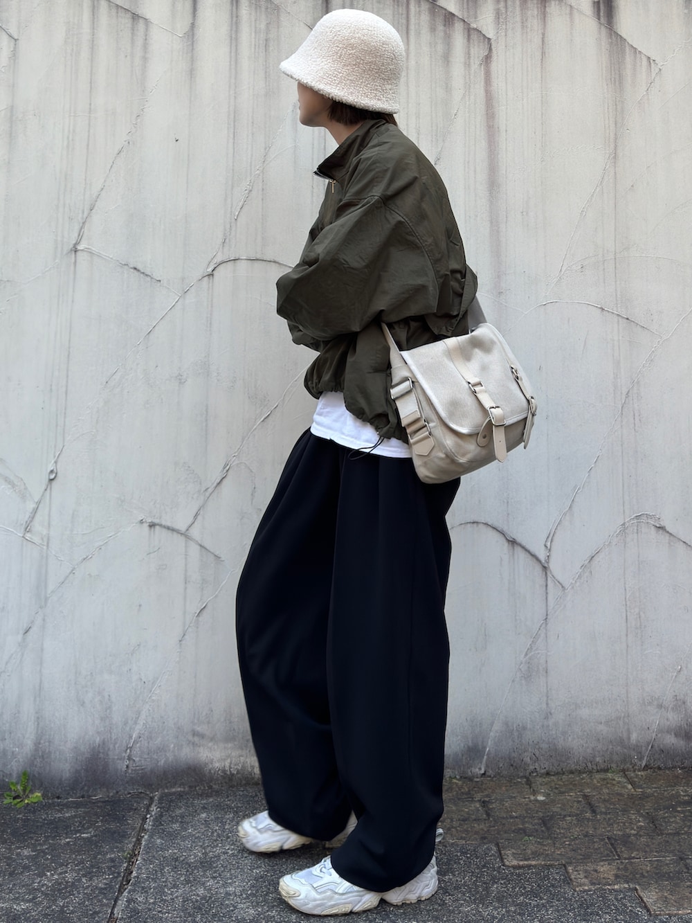グリーン系のその他アウター、ブラック系のその他パンツ、ホワイト系のスニーカーを着用したレディースの春コーディネートの2枚目の写真