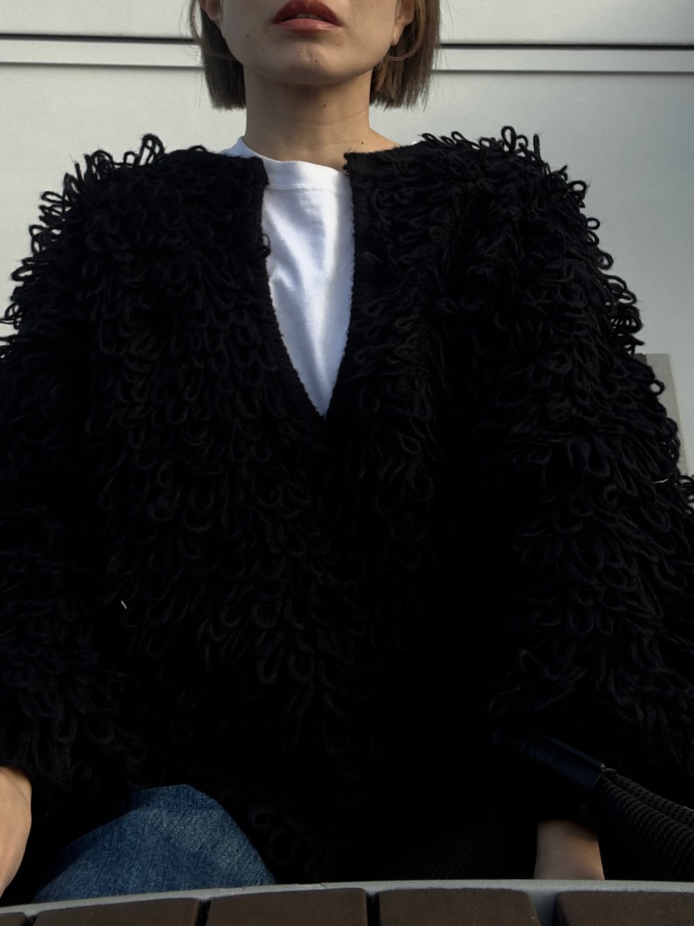 ブルー系のデニムパンツ、ブラック系のトートバッグ、ブラック系のニット/セーターを着用したレディースの冬コーディネートの3枚目の写真