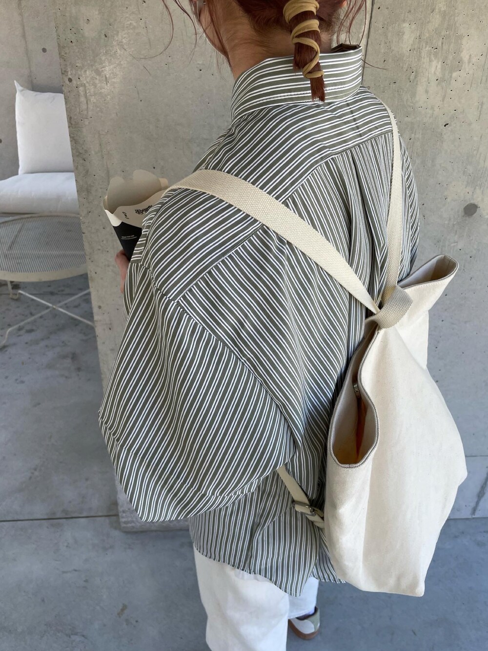 グリーン系のシャツ/ブラウス、ホワイト系のバックパック/リュック、ホワイト系のデニムパンツを着用したレディースの春コーディネートの2枚目の写真