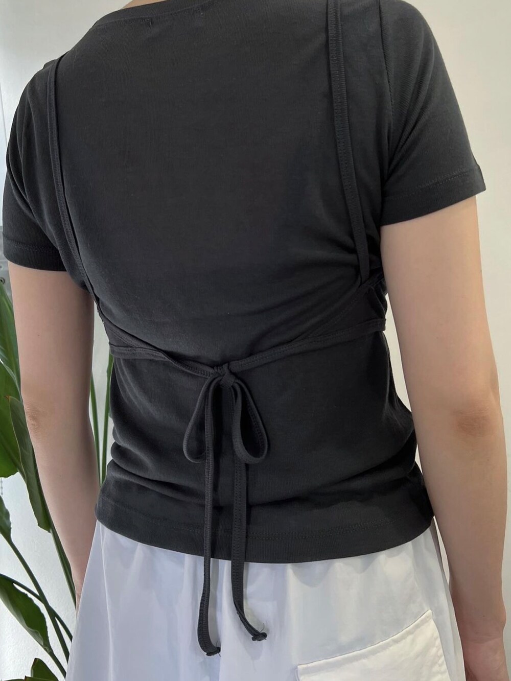 ブラック系のサンダル、グレー系のTシャツ/カットソー、ホワイト系のパンツを着用したレディースの夏コーディネートの2枚目の写真