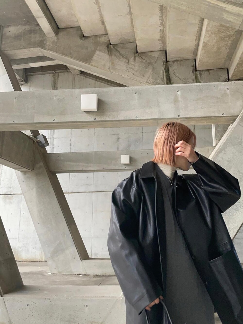 ホワイト系のTシャツ/カットソー、グレー系のワンピース、ブラック系のステンカラーコートを着用したレディースの冬コーディネートの3枚目の写真
