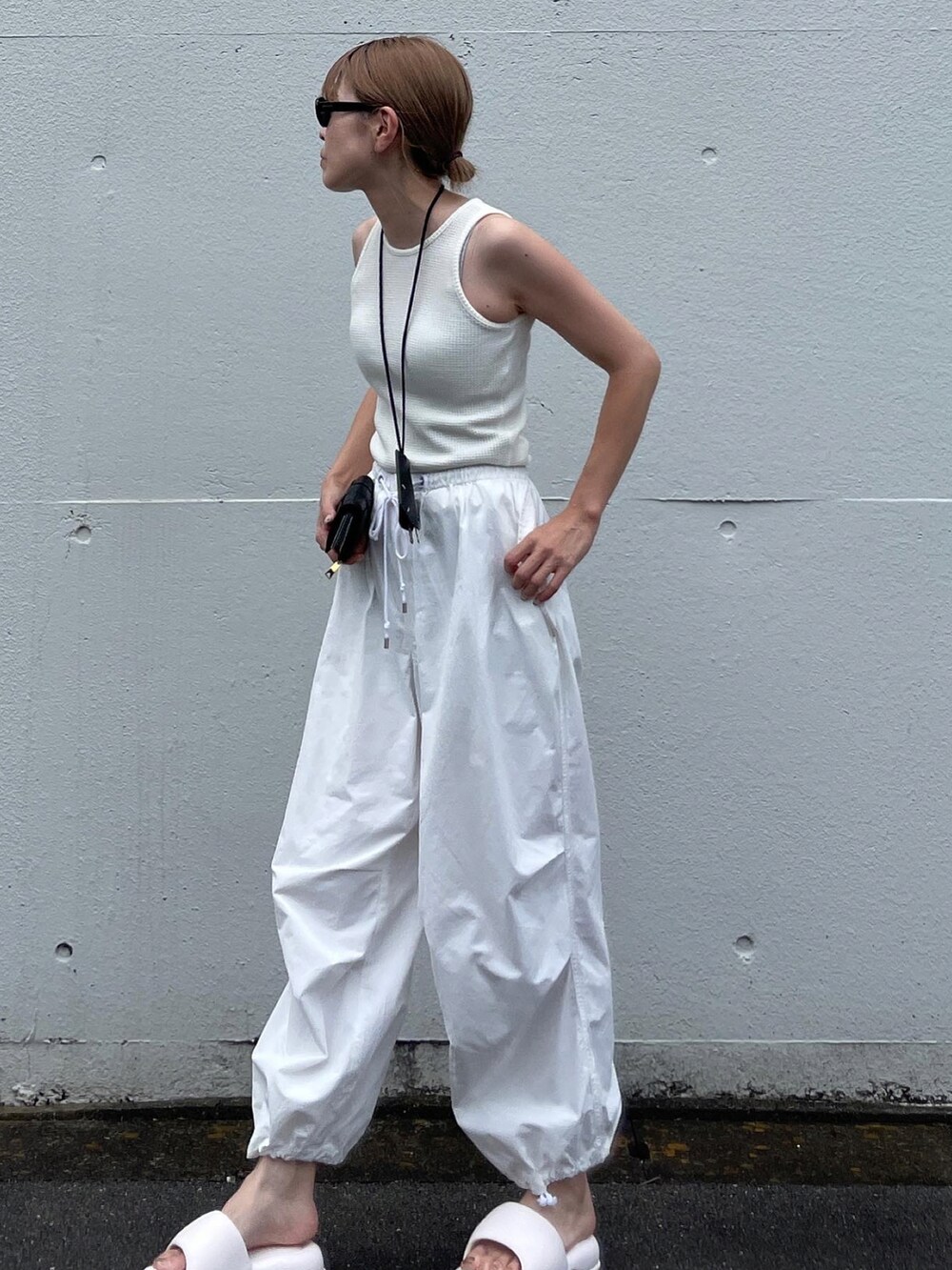 ホワイト系のタンクトップ、ホワイト系のその他パンツ、ホワイト系のサンダルを着用したレディースの夏コーディネートの3枚目の写真