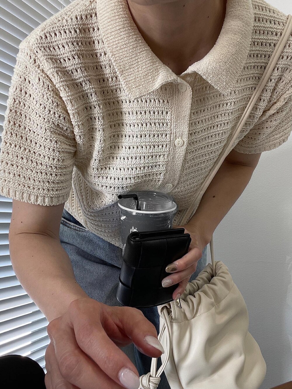 ホワイト系のカーディガン/ボレロ、ブルー系のデニムパンツ、ホワイト系のスニーカーを着用したレディースの夏コーディネートの2枚目の写真