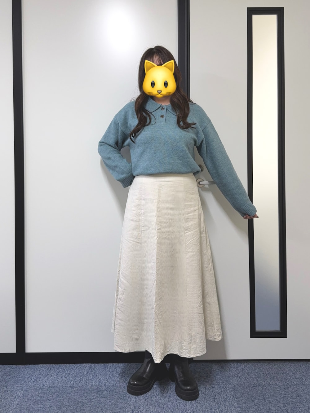 ブルー系のニット/セーター、ホワイト系のスカート、ブラック系のブーツを着用したレディースの冬コーディネートの2枚目の写真