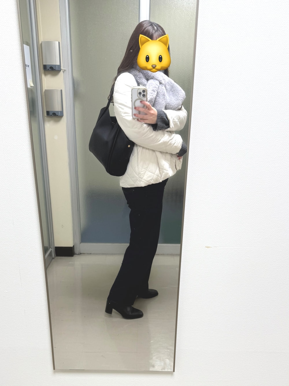 ホワイト系のブルゾン、ブルー系のデニムパンツ、ブラック系のブーツを着用したレディースの冬コーディネートの2枚目の写真