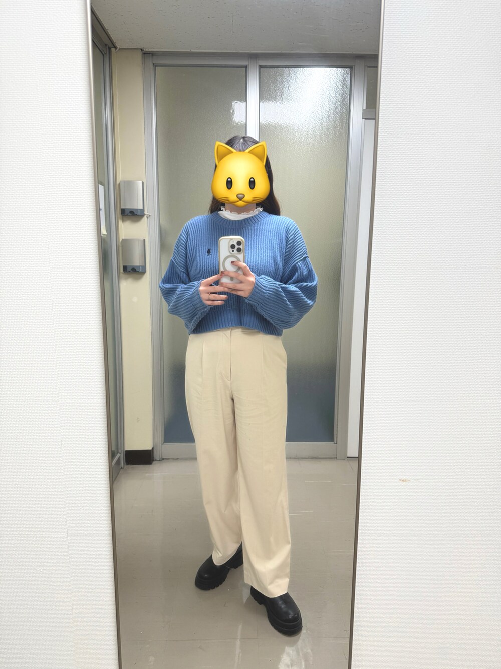 ブラック系のブーツ、ブルー系のニット/セーター、ホワイト系のチノパンツを着用したレディースの秋コーディネートの3枚目の写真