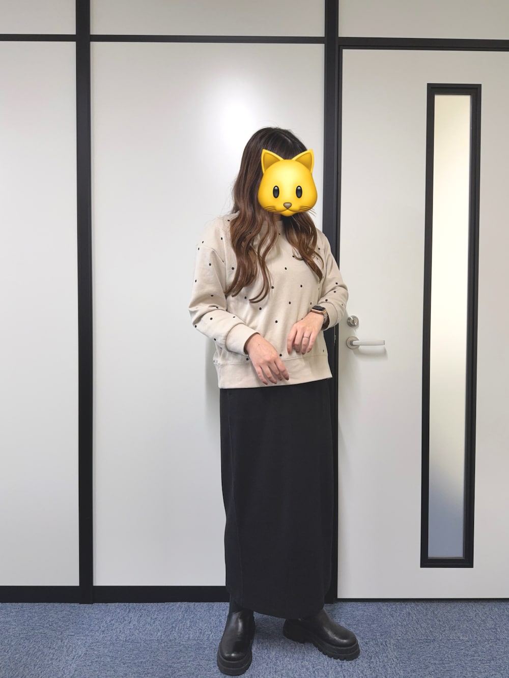 ベージュ系のスウェット、ブラック系のスカート、ブラック系のブーツを着用したレディースの秋コーディネートの2枚目の写真