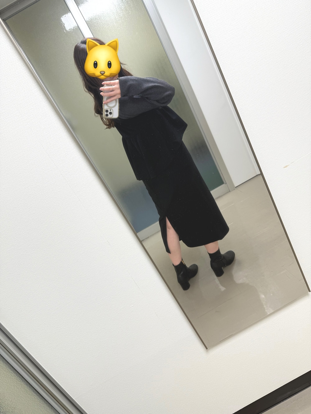 ブラック系のジャンパースカート、ブラック系のブーツ、グレー系のニット/セーターを着用したレディースの冬コーディネートの3枚目の写真