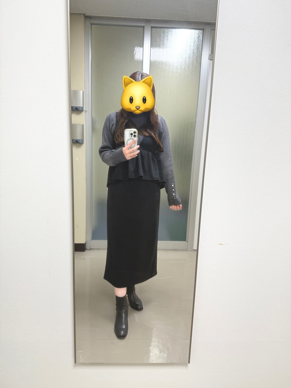 ブラック系のジャンパースカート、ブラック系のブーツ、グレー系のニット/セーターを着用したレディースの冬コーディネートの2枚目の写真