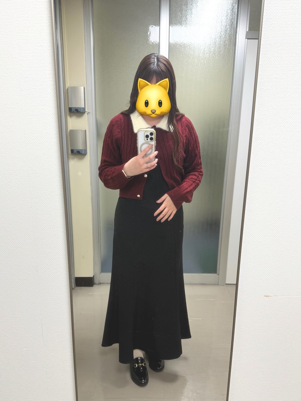 レッド系のトップス、ブラック系のワンピース、ブラック系のローファーを着用したレディースの冬コーディネートの2枚目の写真