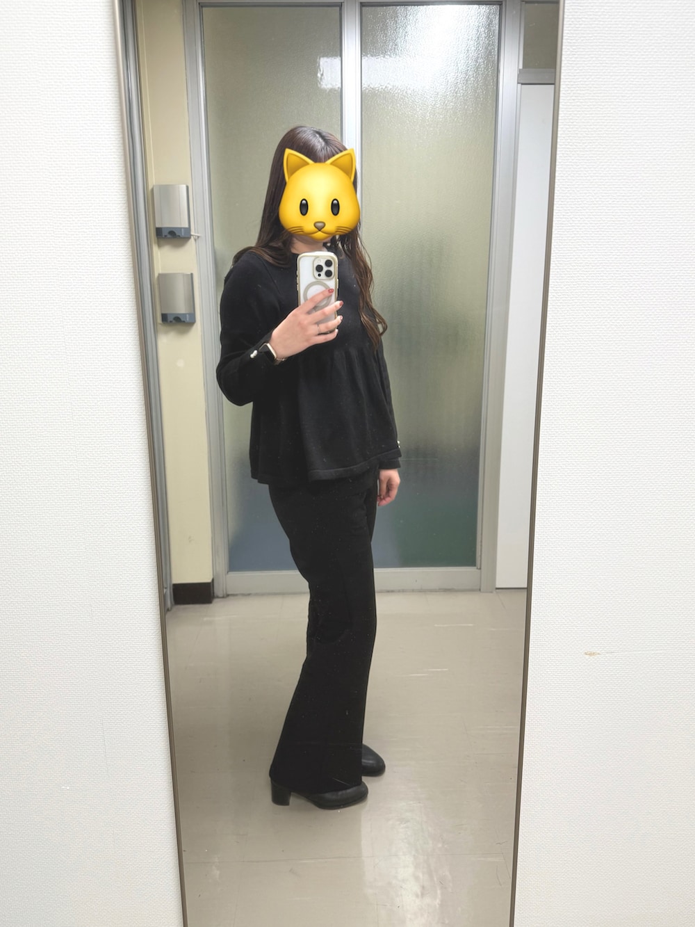 ブラック系のトップス、ブラック系のスラックス、ブラック系のブーツを着用したレディースの冬コーディネートの2枚目の写真