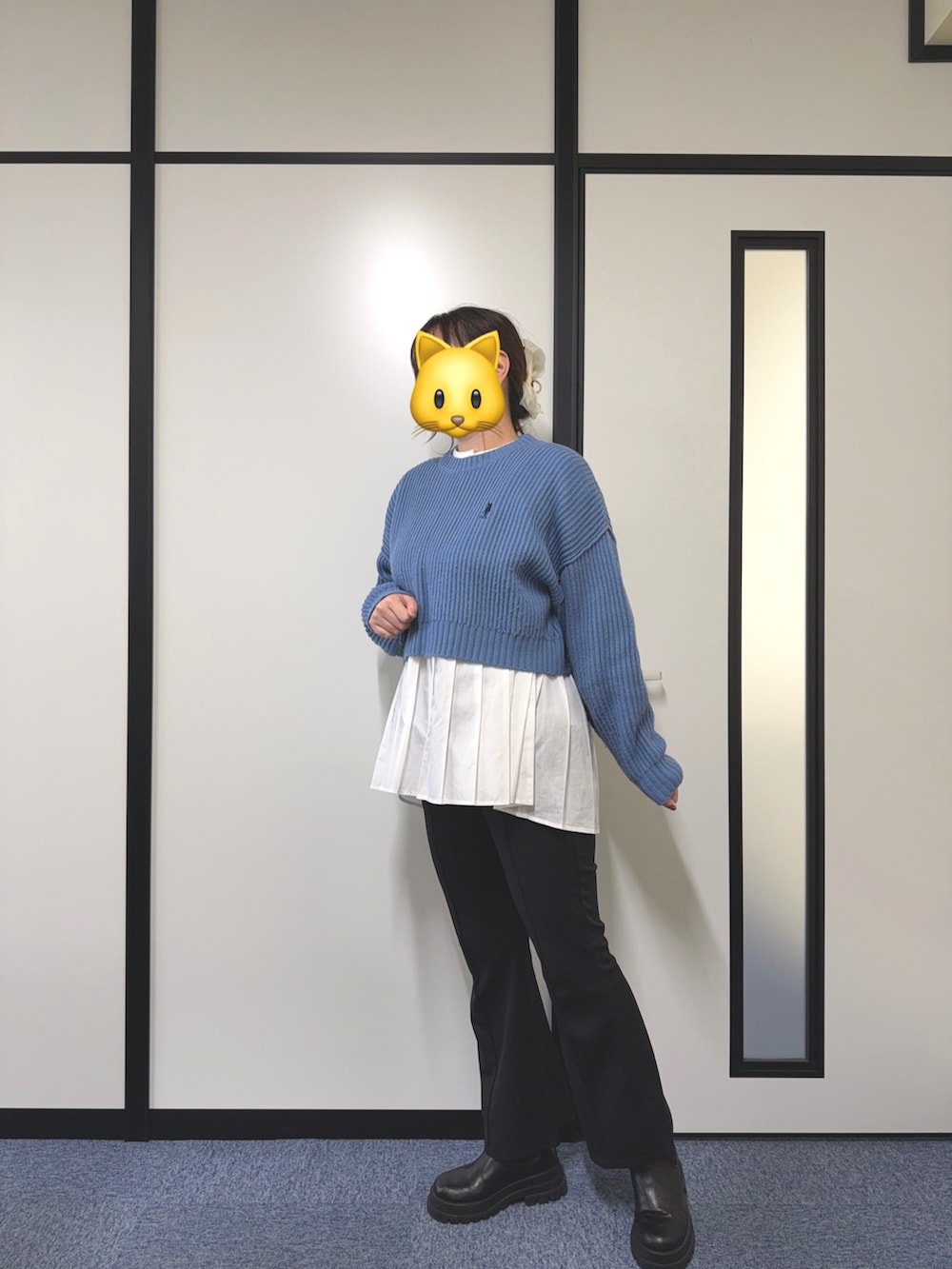 ブルー系のニット/セーター、ホワイト系のシャツ/ブラウス、ブラック系のスラックスを着用したレディースの秋コーディネートの2枚目の写真