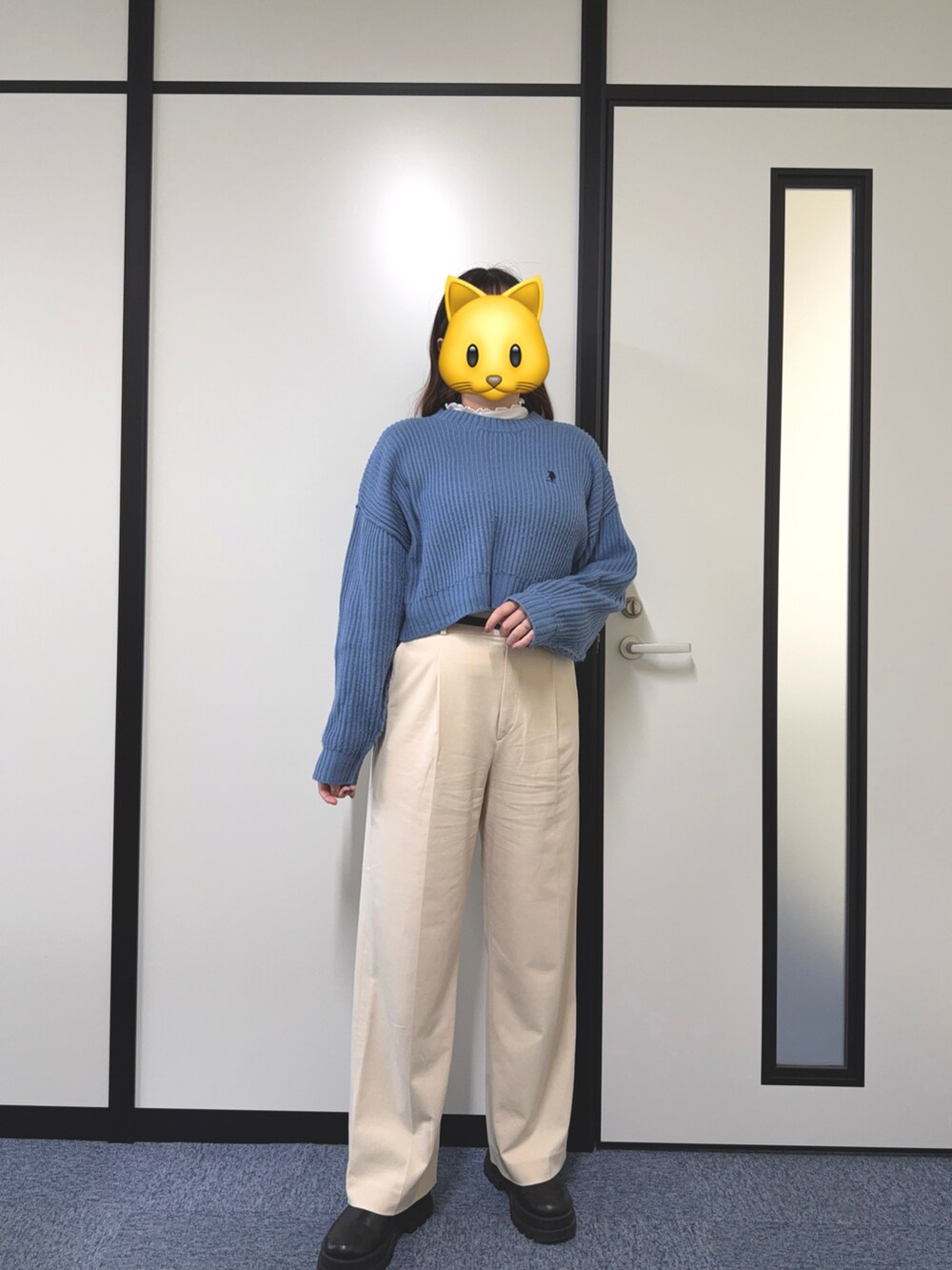 ブラック系のブーツ、ブルー系のニット/セーター、ホワイト系のチノパンツを着用したレディースの秋コーディネートの2枚目の写真