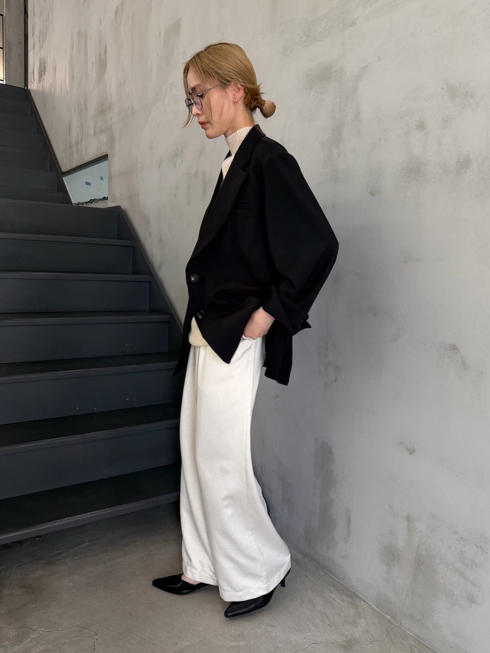 ブラック系のテーラードジャケット、ホワイト系のニット/セーター、ブラック系のショルダーバッグを着用したレディースの春コーディネートの6枚目の写真