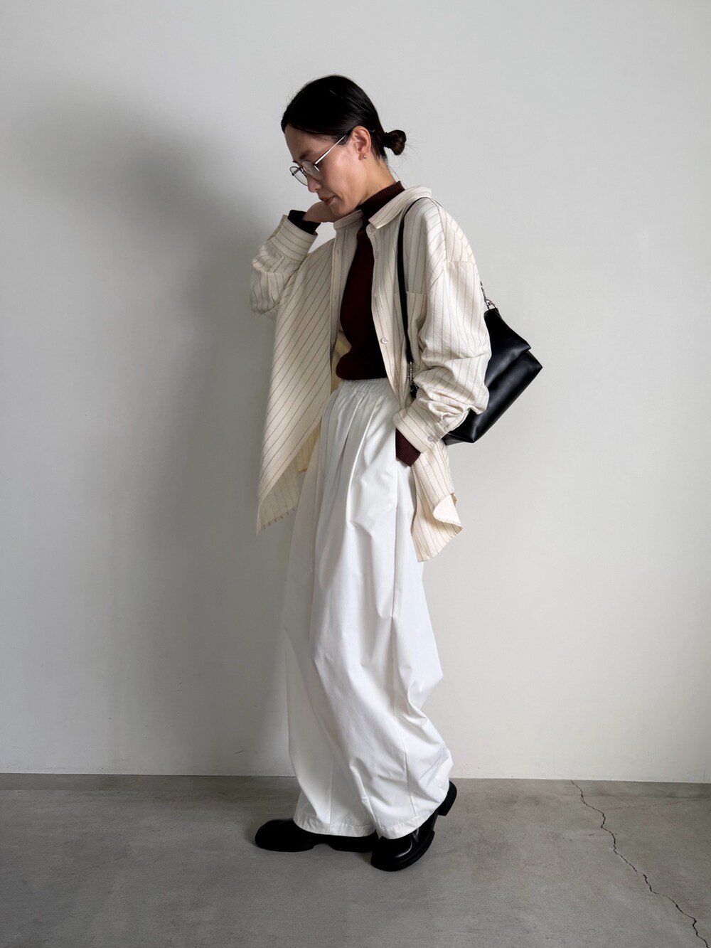 ブラウン系のニット/セーター、ホワイト系のその他パンツ、ブラック系のスリッポンを着用したレディースの冬コーディネートの3枚目の写真