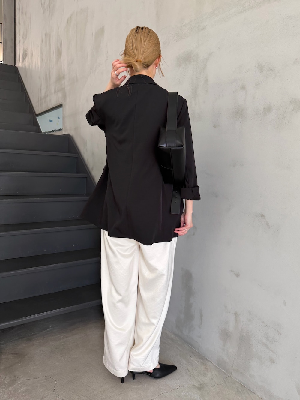 ブラック系のテーラードジャケット、ホワイト系のニット/セーター、ブラック系のショルダーバッグを着用したレディースの春コーディネートの8枚目の写真