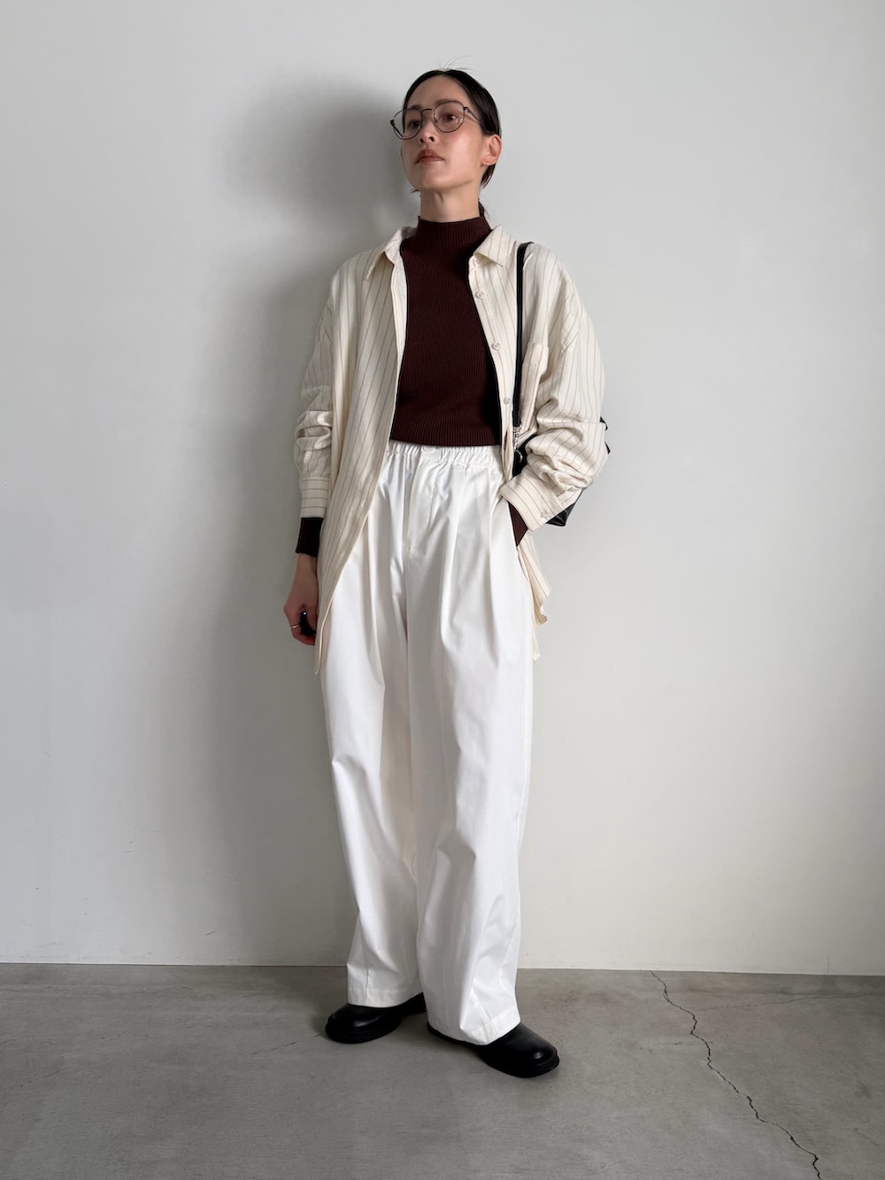 ブラウン系のニット/セーター、ホワイト系のその他パンツ、ブラック系のスリッポンを着用したレディースの冬コーディネートの2枚目の写真