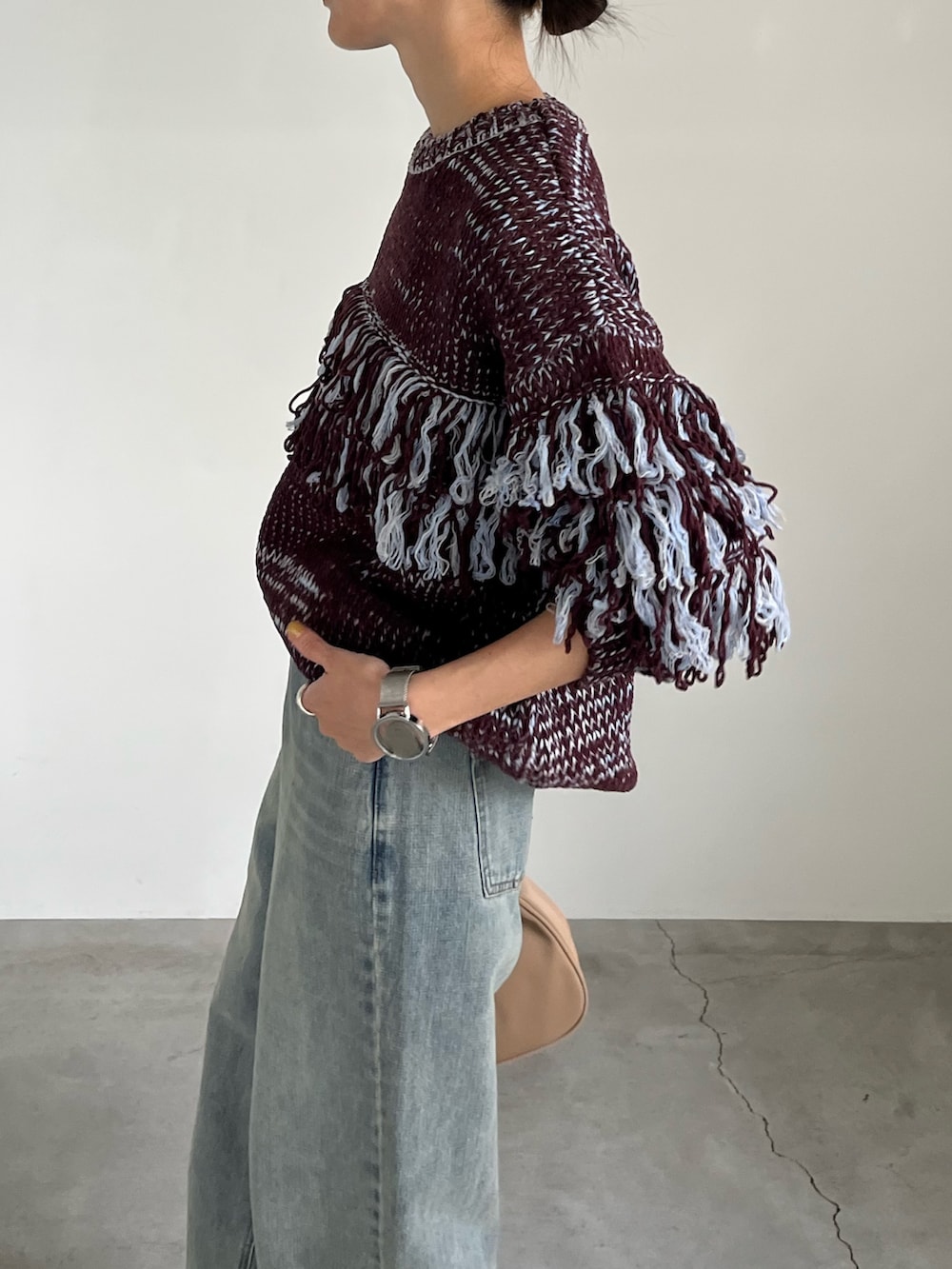 ブラウン系のニット/セーター、ブルー系のデニムパンツ、ベージュ系のショルダーバッグを着用したレディースの秋コーディネートの3枚目の写真