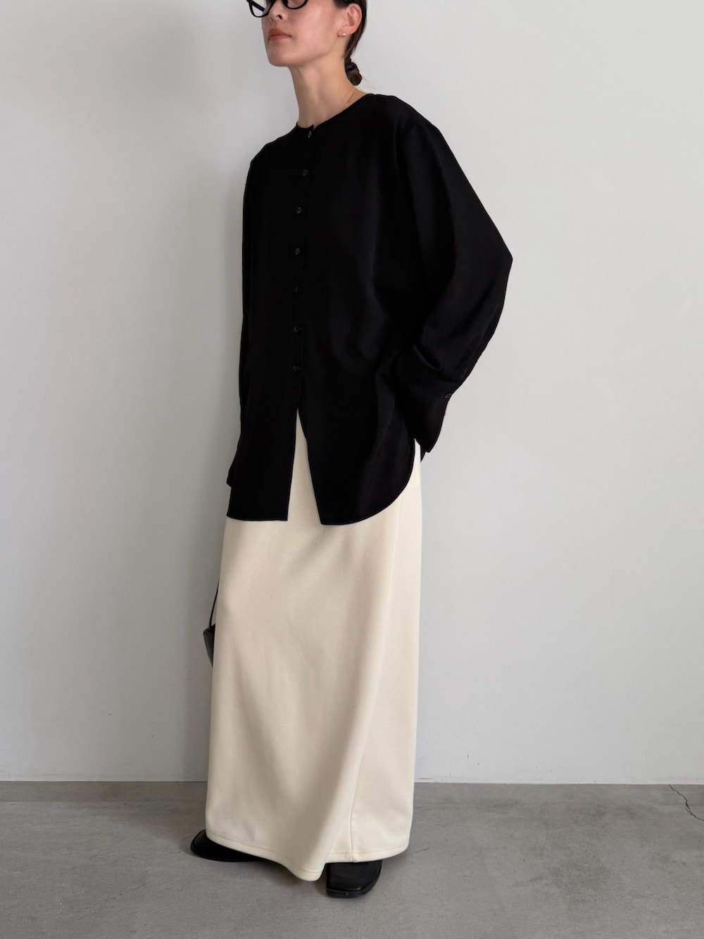 ホワイト系のスカート、ブラック系のシャツ/ブラウスを着用したレディースの冬コーディネートの9枚目の写真