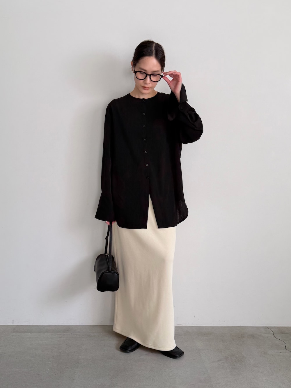 ホワイト系のスカート、ブラック系のシャツ/ブラウスを着用したレディースの冬コーディネートの4枚目の写真