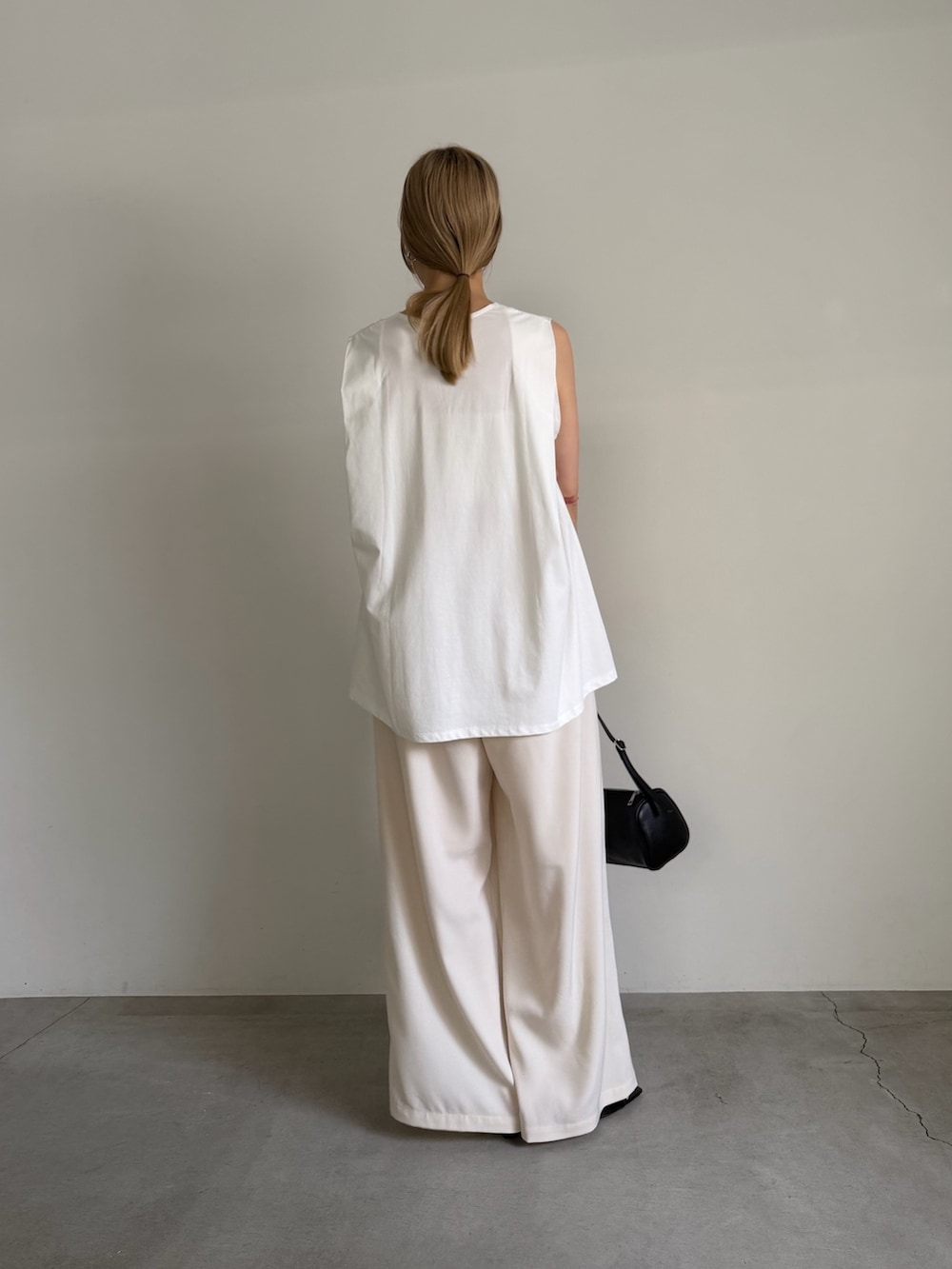 ホワイト系のTシャツ/カットソー、ベージュ系のその他パンツ、ブラック系のサンダルを着用したレディースの夏コーディネートの3枚目の写真