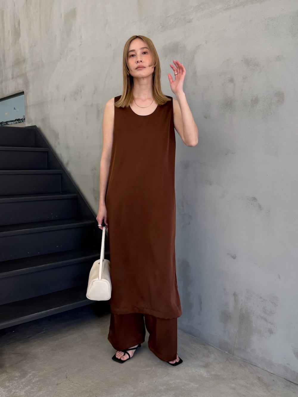 ホワイト系のハンドバッグ、ブラック系のサンダル、ホワイト系のキャミソールを着用したレディースの春コーディネートの4枚目の写真