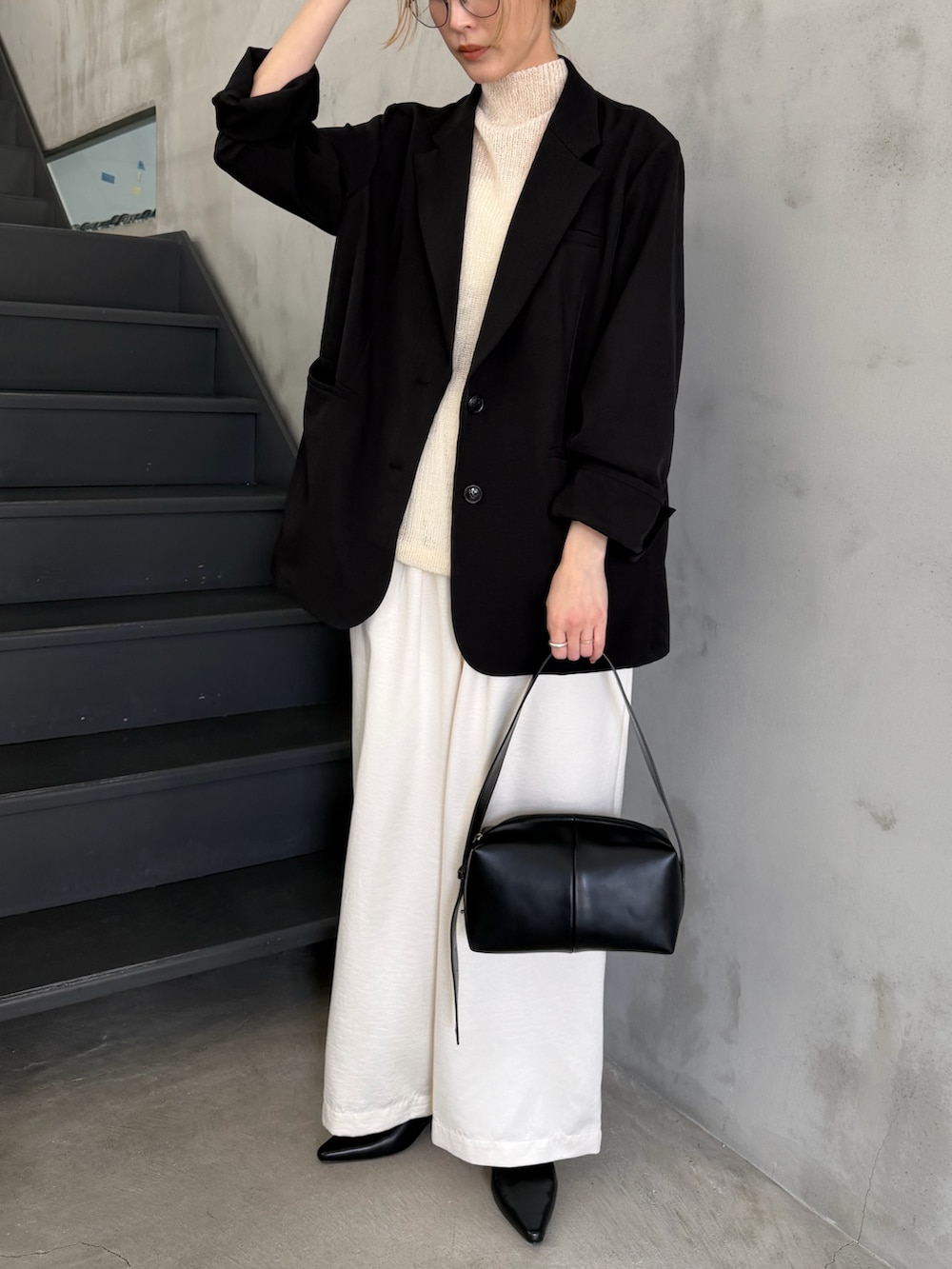 ブラック系のテーラードジャケット、ホワイト系のニット/セーター、ブラック系のショルダーバッグを着用したレディースの春コーディネートの9枚目の写真