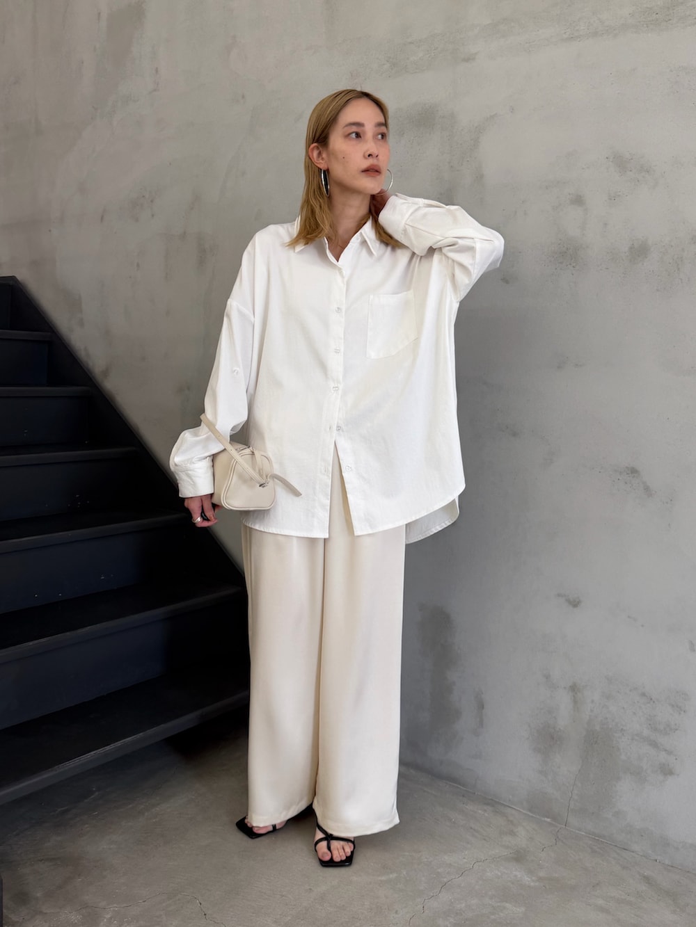 ホワイト系のシャツ/ブラウス、ホワイト系のその他パンツ、ブラック系のサンダルを着用したレディースの春コーディネートの2枚目の写真