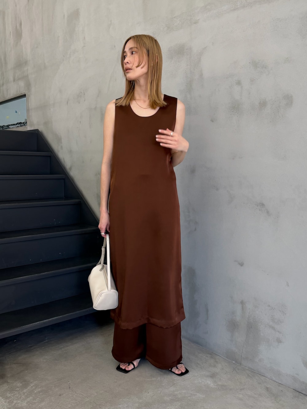 ホワイト系のハンドバッグ、ブラック系のサンダル、ホワイト系のキャミソールを着用したレディースの春コーディネートの2枚目の写真