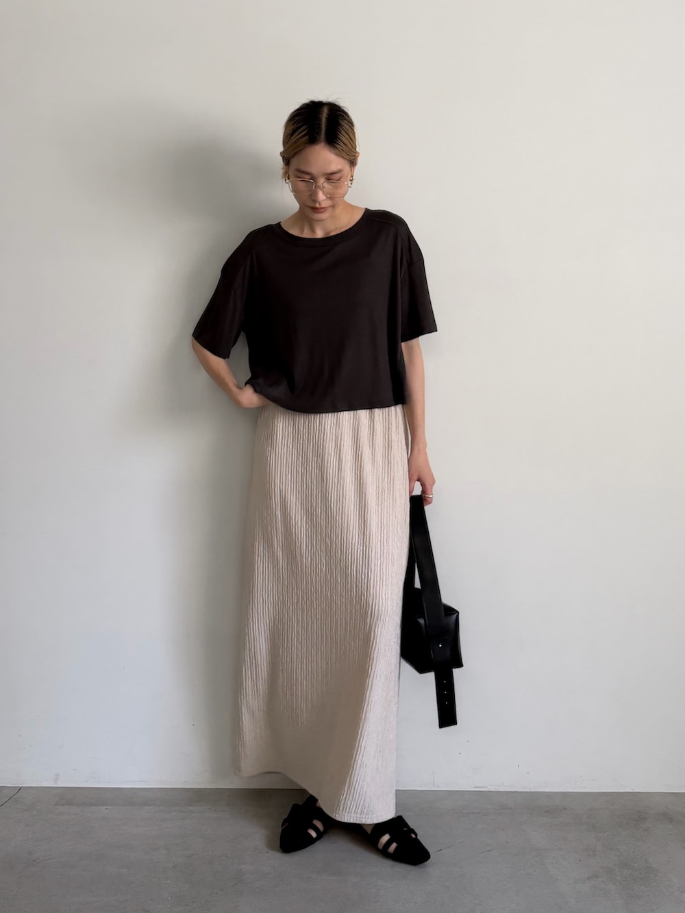 グレー系のTシャツ/カットソー、ベージュ系のスカート、ブラック系のサンダルを着用したレディースの春コーディネートの3枚目の写真