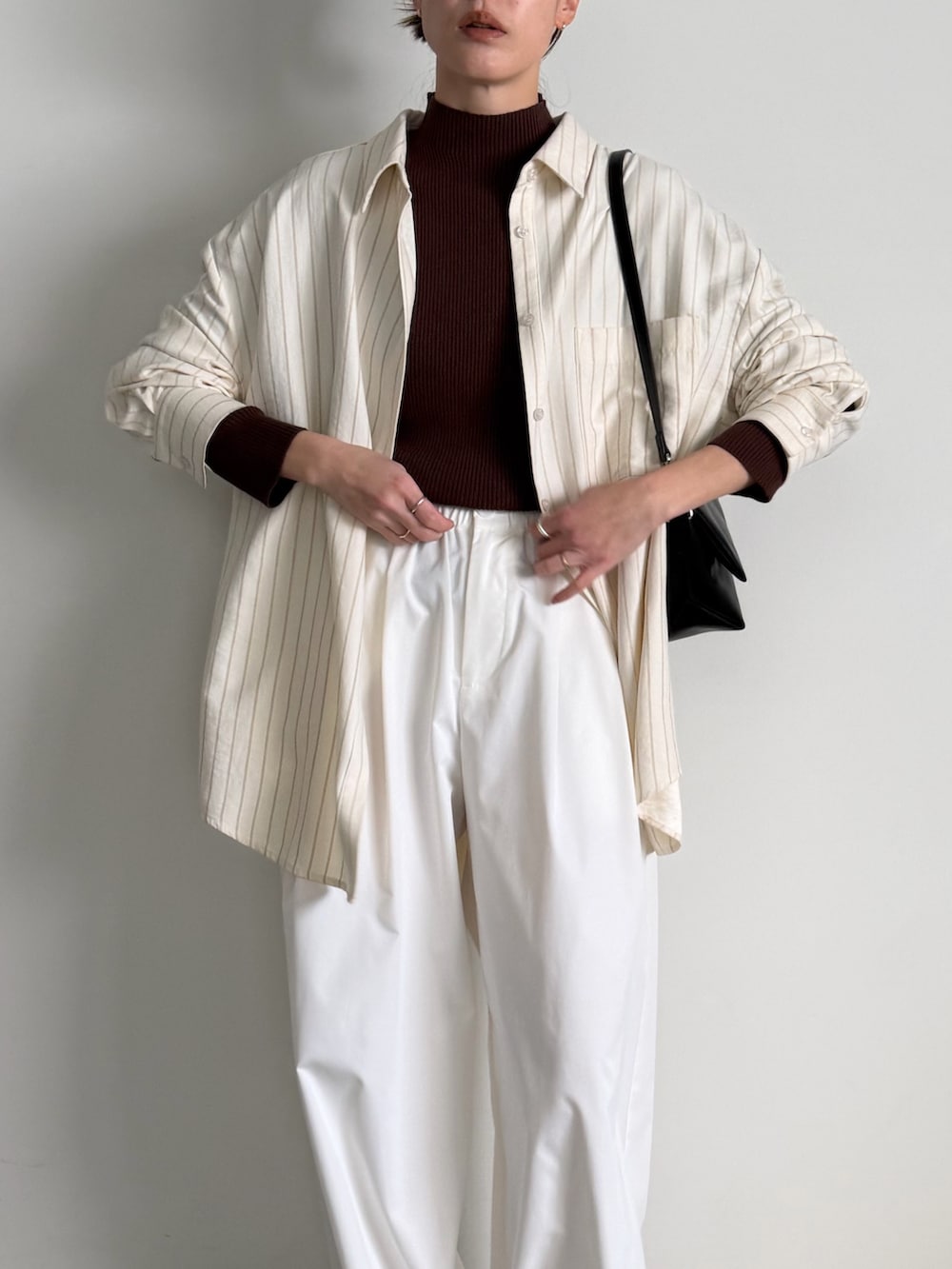 ブラウン系のニット/セーター、ホワイト系のその他パンツ、ブラック系のスリッポンを着用したレディースの冬コーディネートの5枚目の写真