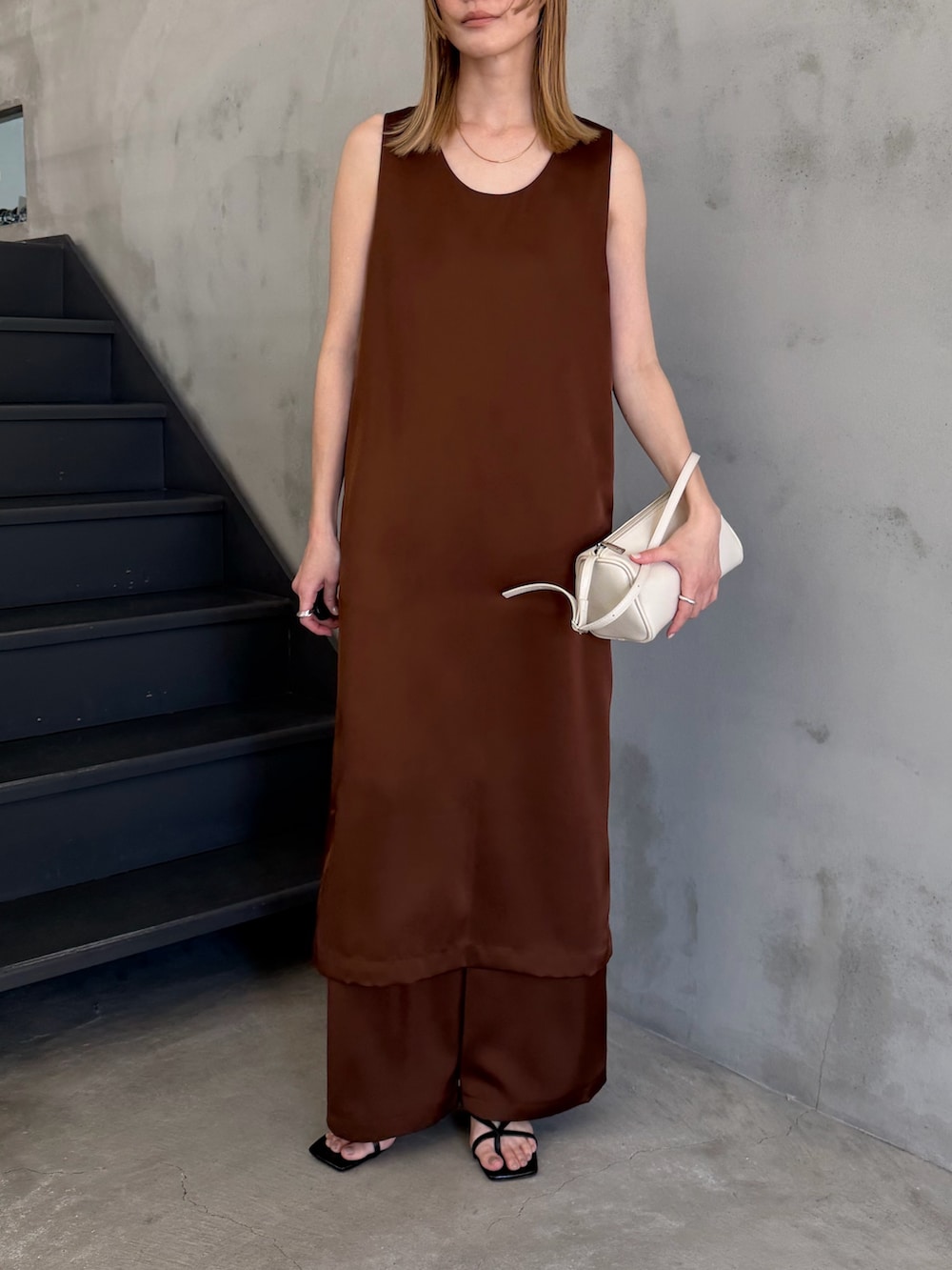 ホワイト系のハンドバッグ、ブラック系のサンダル、ホワイト系のキャミソールを着用したレディースの春コーディネートの6枚目の写真