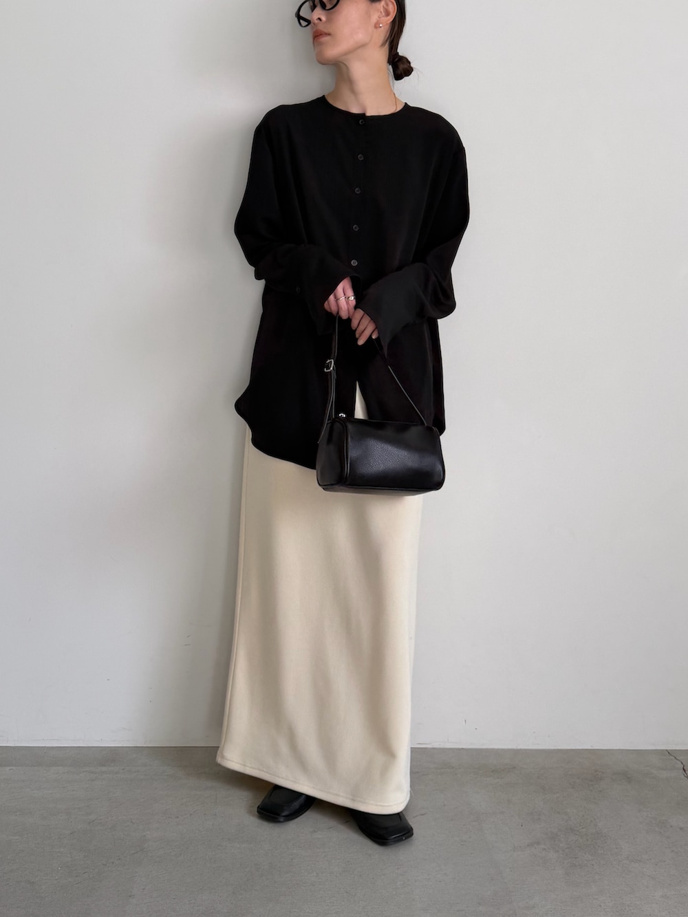 ホワイト系のスカート、ブラック系のシャツ/ブラウスを着用したレディースの冬コーディネートの7枚目の写真