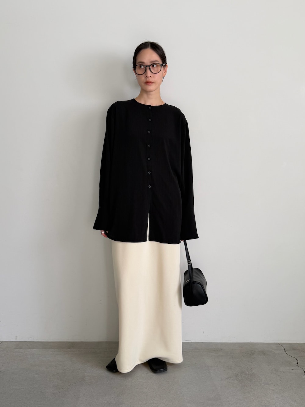 ホワイト系のスカート、ブラック系のシャツ/ブラウスを着用したレディースの冬コーディネートの2枚目の写真